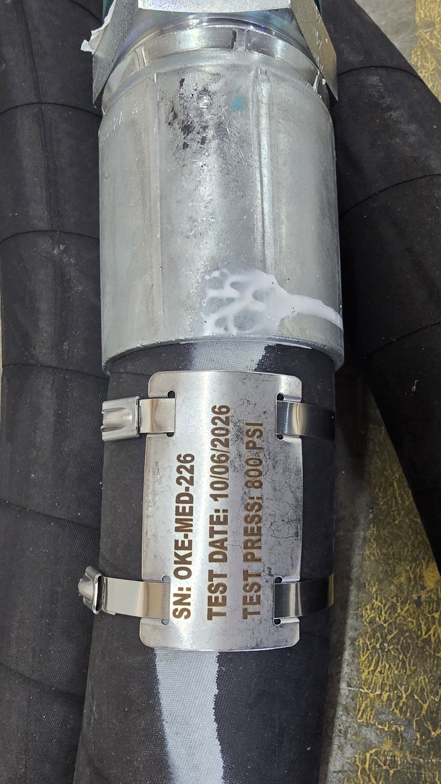 Laser-marked stainless steel tag attached to a hose with two stainless steel zip ties